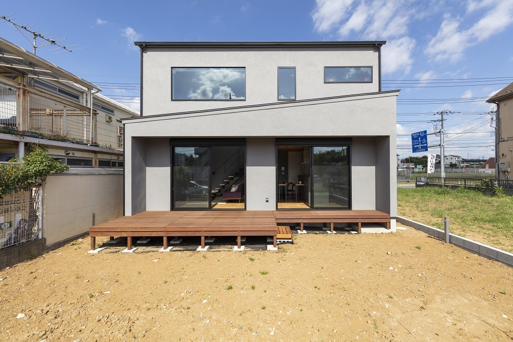 グレーの塗壁に木製のルーバーで優しい印象の外観