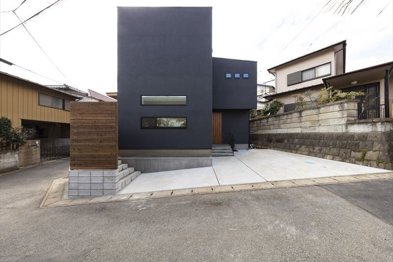 板塀と窓のないグレーの外観が印象的な住まい
