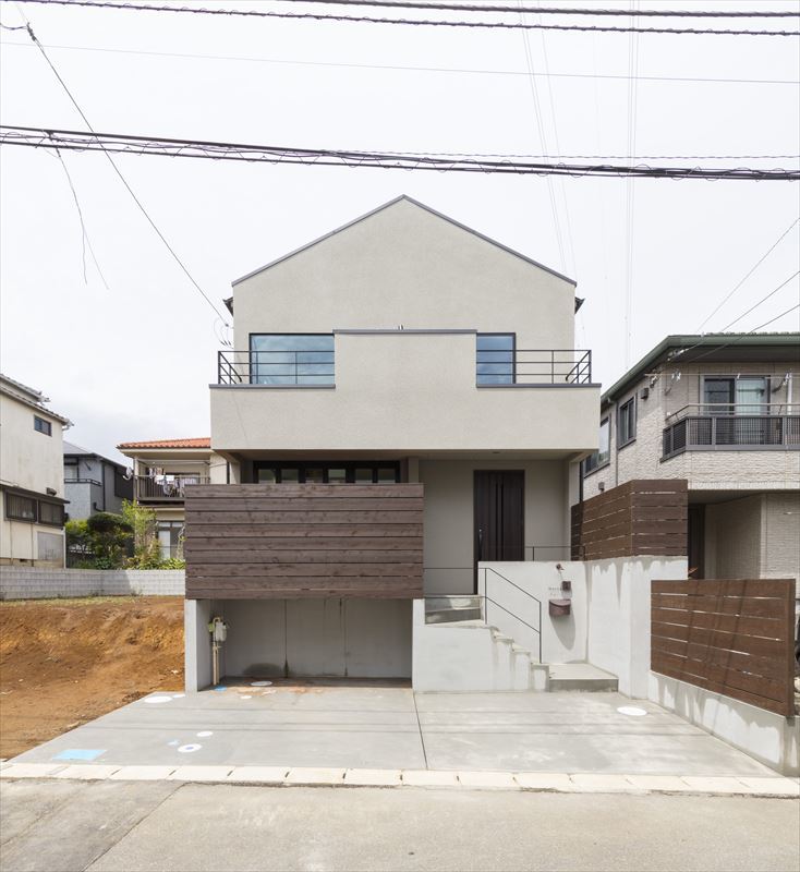 木製フェンスと切妻屋根が街並みに優しい外観の家