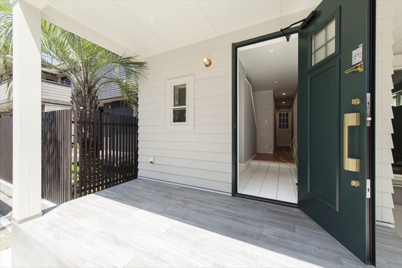 大きな玄関ドアと白のラップサイディングが美しい玄関ポーチ